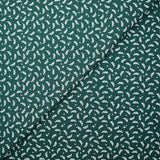 Cotton poplin printed with white twigs and stars on a green background
