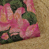 Brocado dorado con flores rosas, fondo verde.