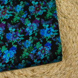 Maille de viscose satinée imprimée champs de fleurs bleu fond noir