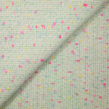 Tweed de laine mélangée confettis rose et bleu fond vert